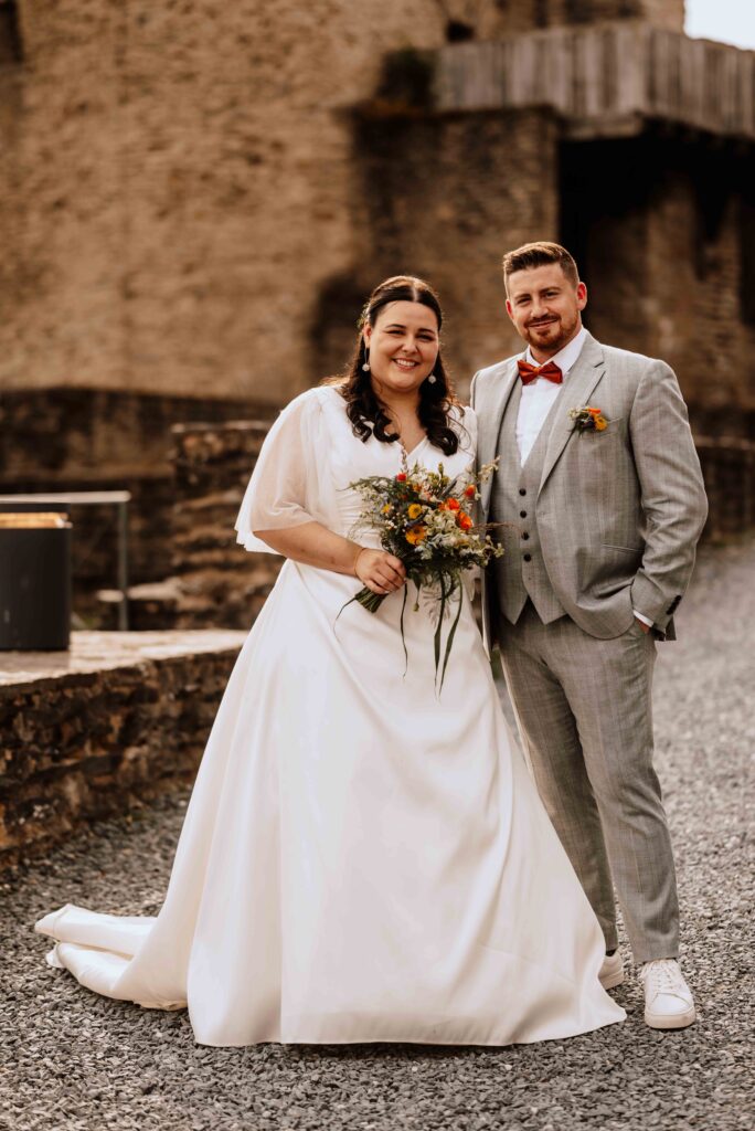 Brautpaar steht vor Schlosslocation