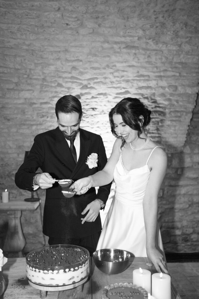 Braut und Bräutigam dekorieren bei ihrer Hochzeit mit Freude eine Torte.
